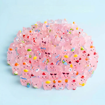 Assorted translucent pink pig figurines with colorful summer accessories arranged together
