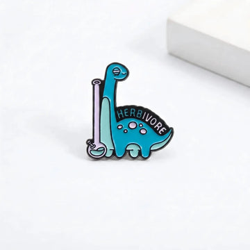 Blue Herbivore dinosaur science enamel pin on a Tiny Relics backing card