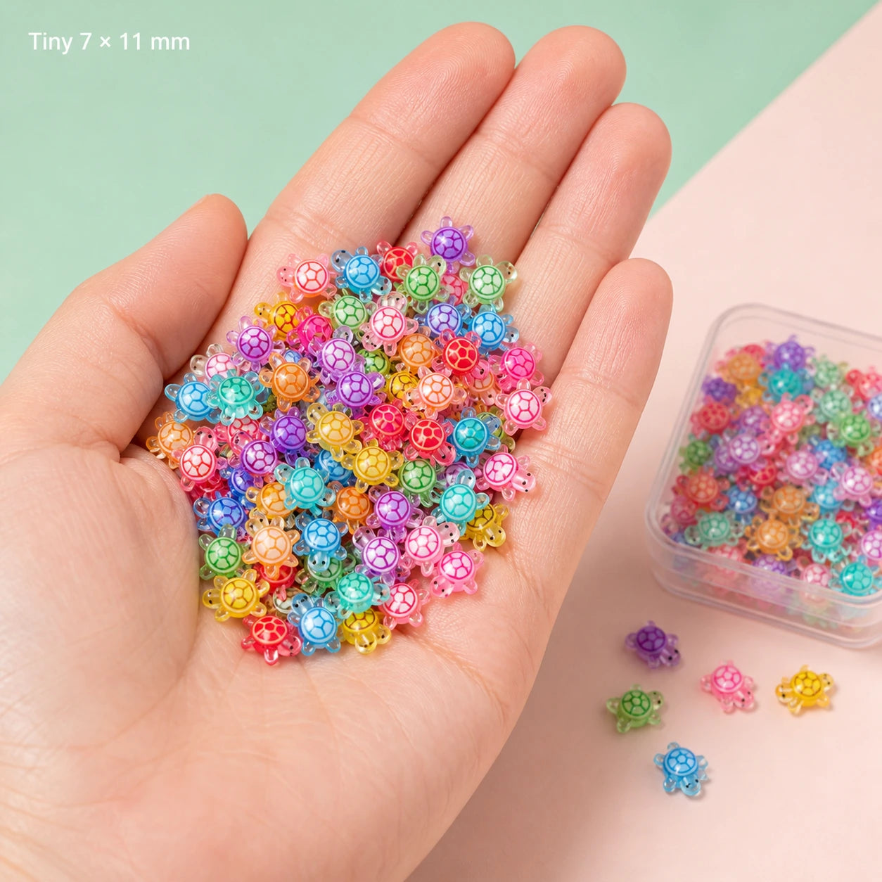 Hand holding tiny multicolor resin turtle charms