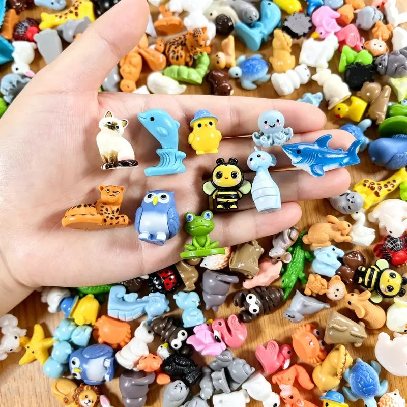 Hand holding assorted tiny animal figurines for scale